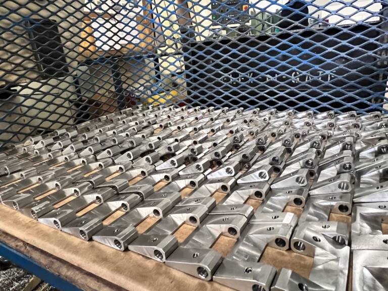 A batch of machined components racked at Ranmar